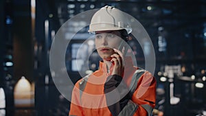 Plant employee talking cell phone at industrial workshop closeup. Woman engineer