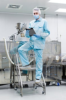 Plant picture, factory worker making notes about machine, stand