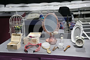 Plant pots in a bird cage on a table with glass comb Jewelry box alarm clock picture frame Makeup accessories