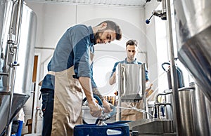 Plant workers operate equipment on productions of craft drink and modern plant