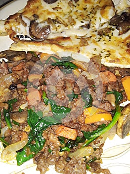 Plantbased meat with fresh sauteed mushrooms onions spinach red yellow and orange bell peppers with mushroom cheese truffle pizza