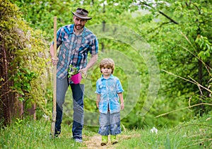 Planting flowers. Dad teaching little son care plants. Little helper in garden. Make planet greener. Growing plants