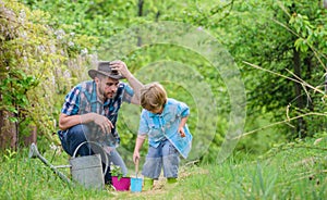 Planting flowers. Dad teaching little son care plants. Little helper in garden. Make planet greener. Growing plants