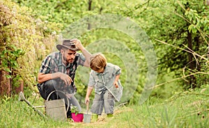 Planting flowers. Dad teaching little son care plants. Little helper in garden. Make planet greener. Growing plants