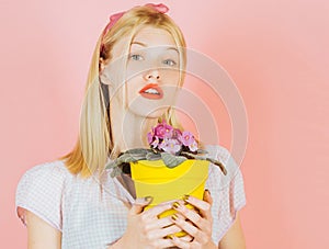 Planting flowers.Gardener woman planting flowers. Cute blonde gardening at isolated background.