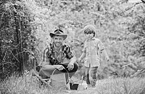 Planting flowers. Growing plants. Take care of plants. Boy and father in nature with watering can. Gardening tools. Dad