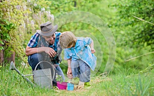 Planting flowers. Make planet greener. Growing plants. Take care of plants. Boy and father in nature with watering can