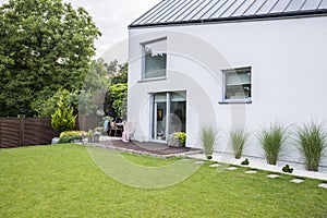 Plants, flowers and garden furniture on a wooden terrace outside photo