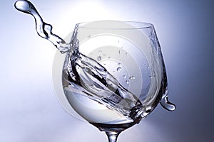 Plash of water from a wine glass on a light background