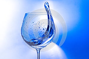 Plash of water from a wine glass on a light background