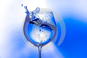 Plash of water from a wine glass on a light background