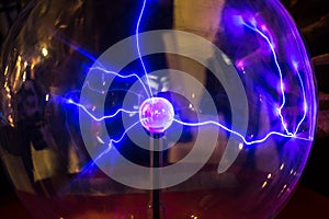 Plasma ball with smooth magenta-blue flames on a dark background.