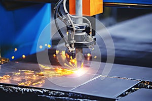 Plasma cutting CNC machine cuts metal material with sparks, industry background