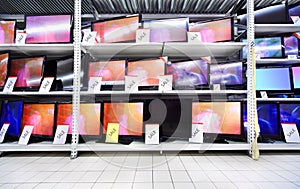 Plasma TVs stand on shelves in large store