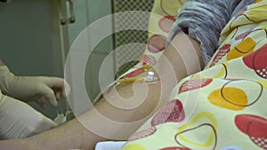 Plasmapheresis. Cleaning the patientâ€™s blood through the device. A nurse removes a catheter from a patient`s vein. She