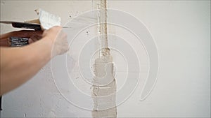 Decorative plaster coating. Man does ragged texture on the wall using a spatula. plaster application on the wall