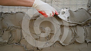 The plaster is applied to the surface with a steel spatula. Decorative plaster based on gray cement, resistant to