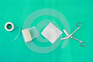 Plaster ,net bandage ,gauzes and scissors for dressing clean wound on medical background with copy space ,middle