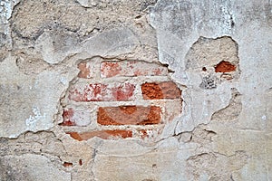 Plaster and red brick wall damage.