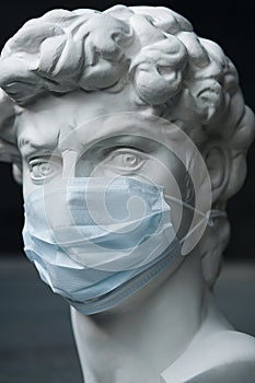Plaster Sculpture In A Medical Mask. Concept Of Air Pollution, Pneumonia Outbreaks, Coronavirus Epidemics, And The Risk Of photo