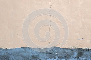 Plastered wall with a crack and fresh cement plaster underneath. Texture of old walls