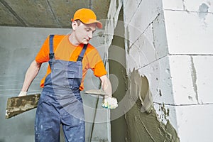 Plasterer applying plaster on block wall. Rennovation