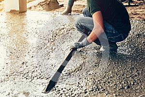 Plasterer concrete worker at floor of house construction