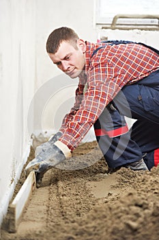 Plasterer concrete worker at floor work