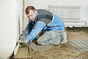 Plasterer concrete worker at floor work