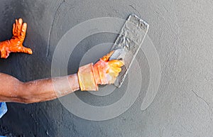 Plasterer concrete worker at wall of house construction