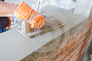 Plasterer concrete worker at wall of house construction