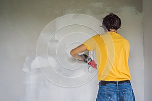 Plasterer home improvement handyman worker with putty knife working on apartment wall filling