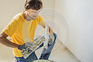 Plasterer home improvement handyman worker with putty knife working on apartment wall filling