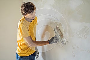 Plasterer home improvement handyman worker with putty knife working on apartment wall filling