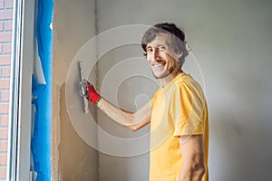 Plasterer home improvement handyman worker with putty knife working on apartment wall filling