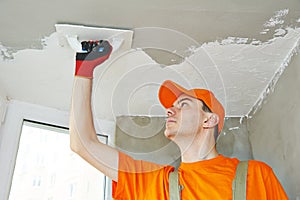 Plasterer at indoor ceiling work