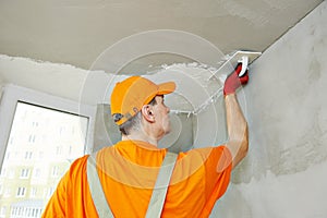 Plasterer at indoor ceiling work