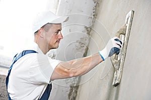 Plasterer at indoor wall renovation