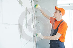 Plasterer installing screed on wall for plastering