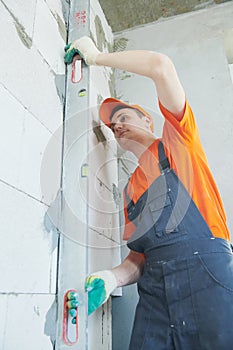 Plasterer levelling screed on wall for plastering