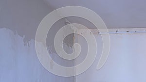 Plasterer man spackling wall with putty plaster aligning wall using trowel.