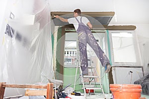 Plasterer renovating indoor walls and ceilings.