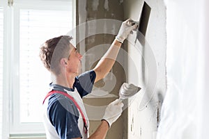 Plasterer renovating indoor walls and ceilings.