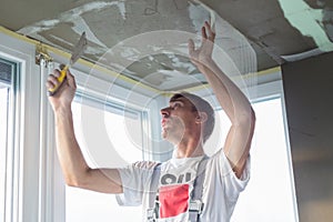 Plasterer renovating indoor walls and ceilings. Finishing works.