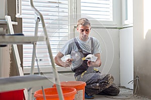 Plasterer renovating indoor walls and ceilings. Finishing works.