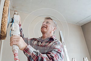 Plasterer smoothing interior wall with machine