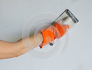 Plasterer smoothing out wall with trowel photo