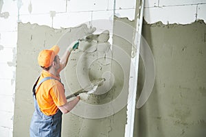 Plasterer spreading plaster on wall. Renovation service