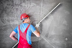 Plasterer at work on construction site, leveling walls and checking quality. Industrial worker on construction site