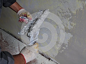 plasterer work with two spatulas and mortar